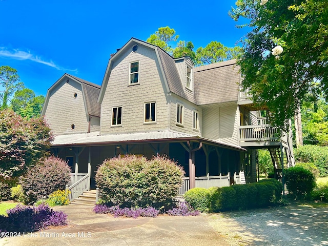 rear view of property featuring covered porch