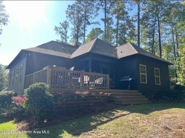 rear view of house featuring a yard and a deck