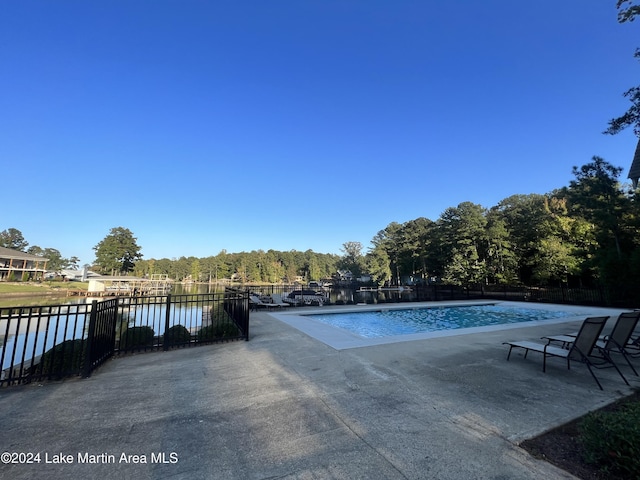 view of pool featuring a patio and a water view