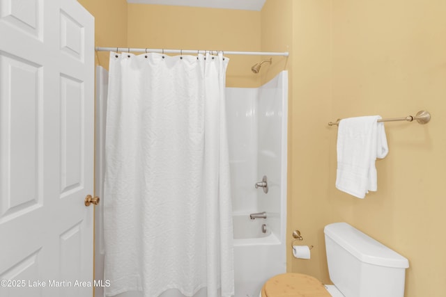 bathroom featuring shower / bath combination with curtain and toilet