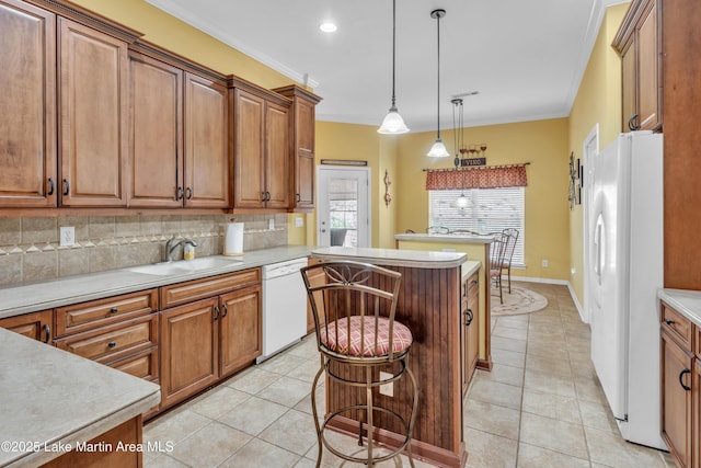 kitchen featuring crown molding, light tile patterned floors, brown cabinets, white appliances, and a sink