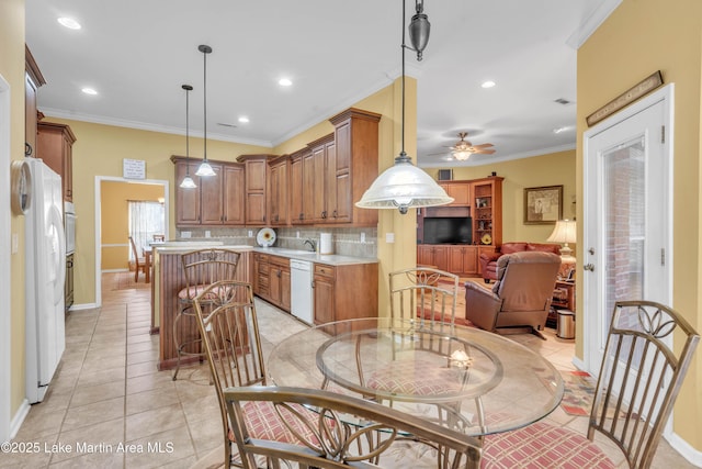 kitchen featuring white appliances, a ceiling fan, ornamental molding, light countertops, and a center island