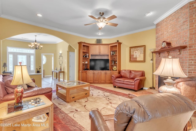 living area with arched walkways, ceiling fan with notable chandelier, and crown molding