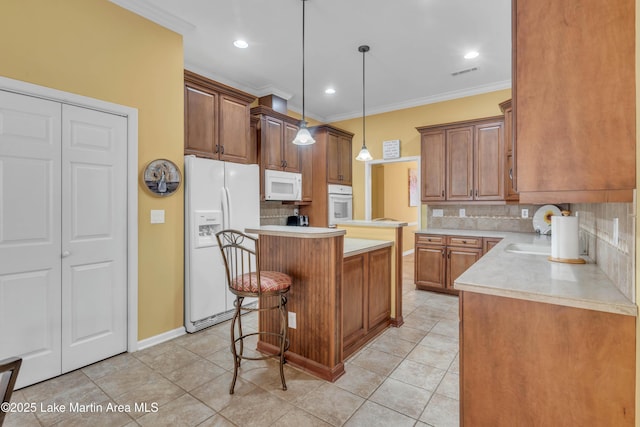 kitchen featuring visible vents, a kitchen island, crown molding, light countertops, and white appliances