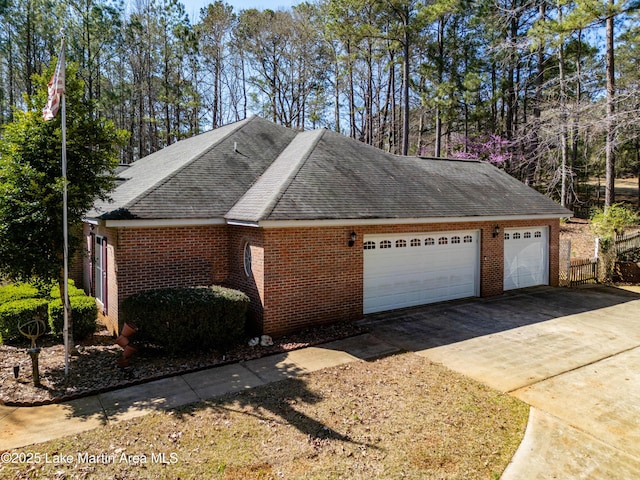 view of side of home featuring an attached garage, brick siding, driveway, and a shingled roof