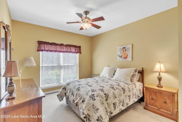 bedroom featuring light carpet and a ceiling fan