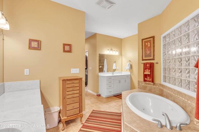 bathroom featuring visible vents, a tub with jets, vanity, and tile patterned flooring