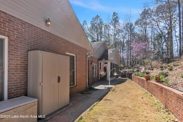 view of side of home featuring a patio and brick siding