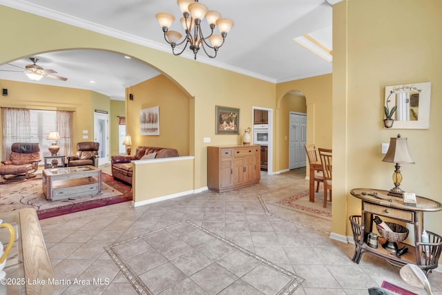 living room with arched walkways, ceiling fan with notable chandelier, crown molding, and baseboards