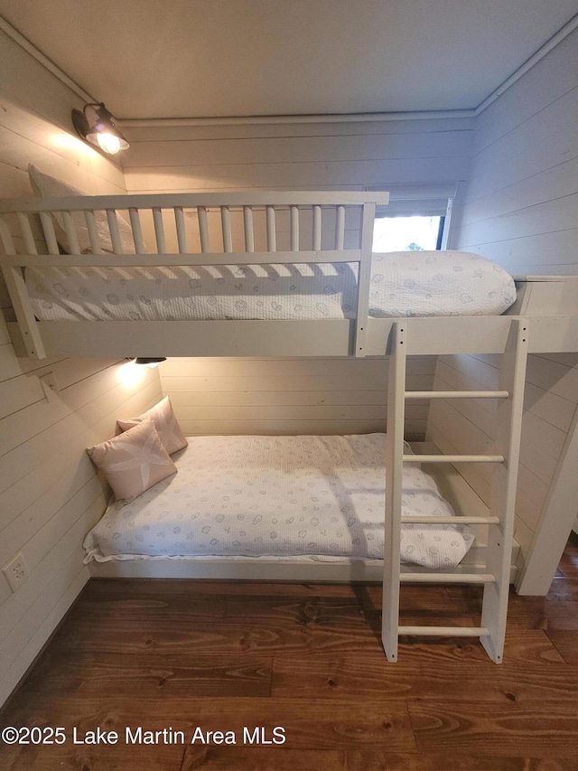 unfurnished bedroom featuring dark hardwood / wood-style floors and wooden walls