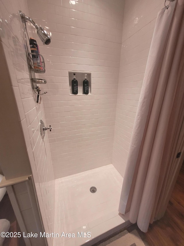 bathroom with curtained shower and wood-type flooring