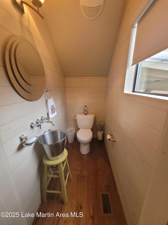 bathroom featuring toilet, lofted ceiling, hardwood / wood-style flooring, and sink