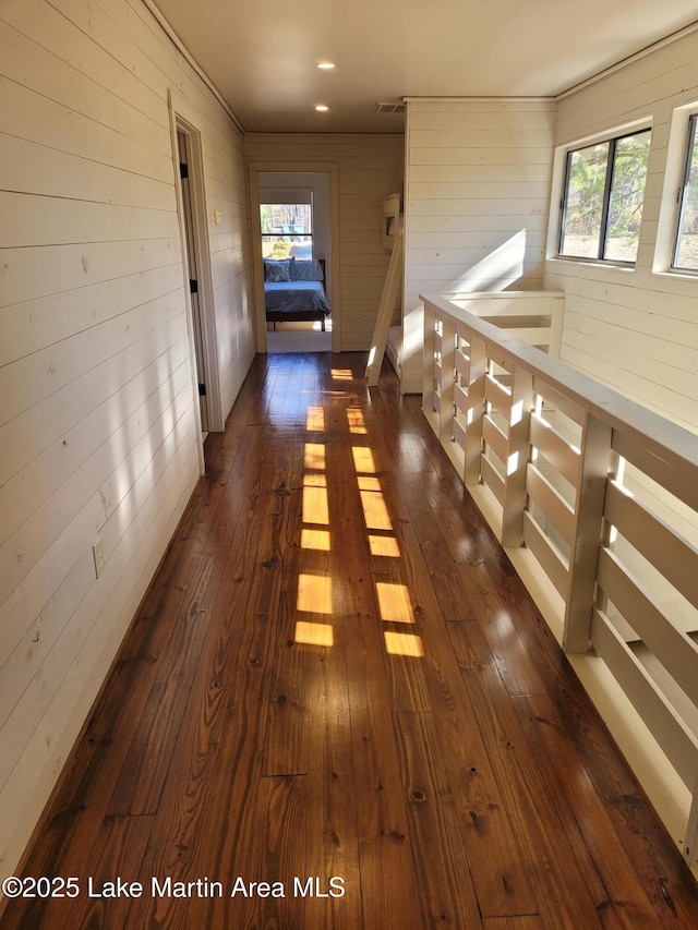 corridor featuring wood walls and dark hardwood / wood-style floors