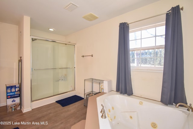 bathroom featuring visible vents, a shower stall, a whirlpool tub, and wood finished floors