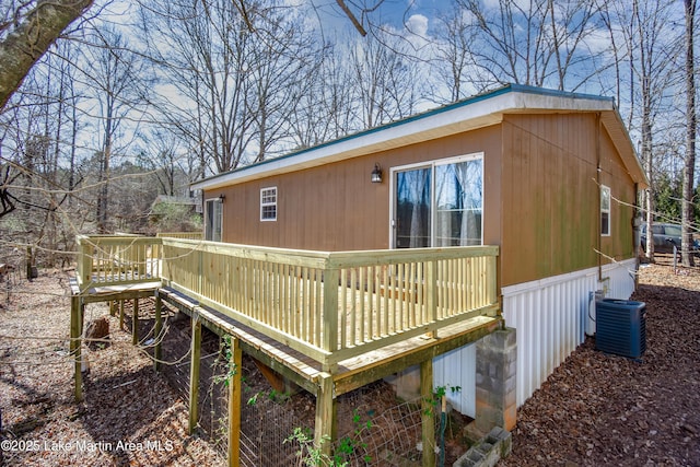 view of side of home with cooling unit and a wooden deck