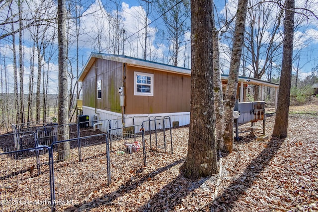 view of property exterior featuring central air condition unit and fence