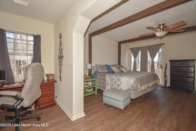 bedroom featuring multiple windows, wood finished floors, and beam ceiling