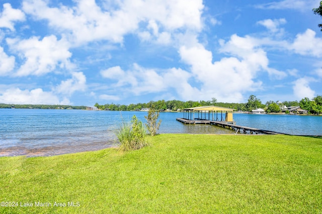 view of dock with a yard and a water view