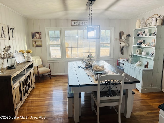 dining space with dark wood-style floors, a wealth of natural light, and crown molding