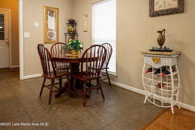 dining space featuring dark tile patterned floors and a healthy amount of sunlight