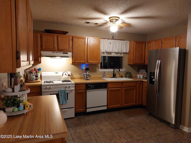 kitchen featuring visible vents, light countertops, a sink, white appliances, and under cabinet range hood