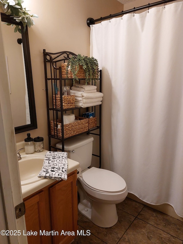 full bath featuring a shower with curtain, tile patterned flooring, vanity, and toilet