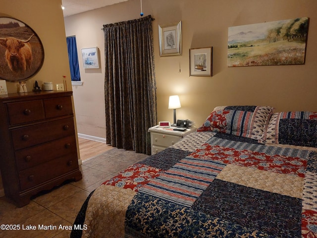 bedroom with baseboards and tile patterned floors