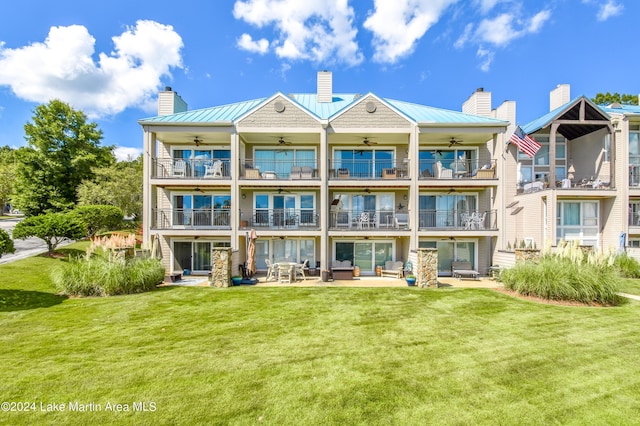 back of property featuring a yard, a patio, a balcony, and ceiling fan