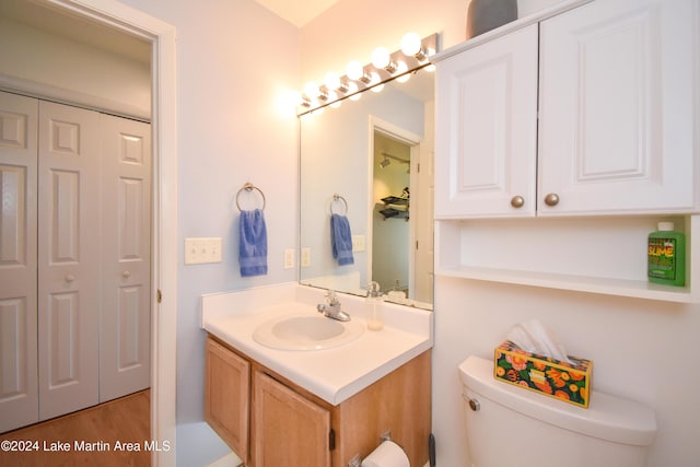 bathroom with vanity, hardwood / wood-style flooring, and toilet