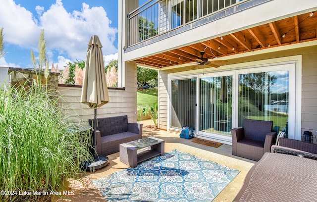 view of patio with ceiling fan, a balcony, and an outdoor living space