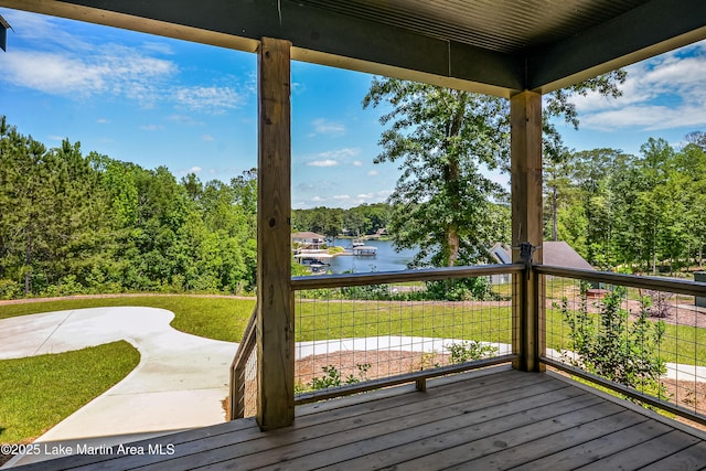 wooden terrace with a water view and view of wooded area