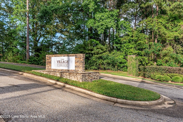 community sign featuring view of wooded area