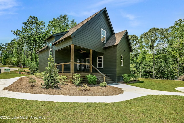 view of front of property featuring covered porch, ceiling fan, a front lawn, and a shingled roof