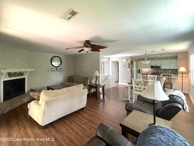 11 Redbud Ct, Dadeville, AL 36853 - living room with a fireplace with raised hearth, a ceiling fan, and dark wood-style floors