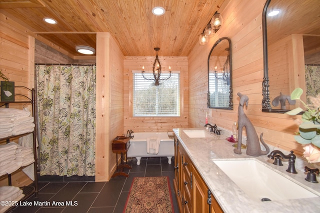 bathroom featuring tile patterned floors, wood ceiling, vanity, wooden walls, and a bathtub