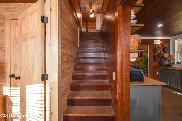 staircase with wood ceiling and wooden walls