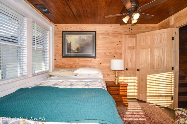 bedroom with wooden walls and wood ceiling