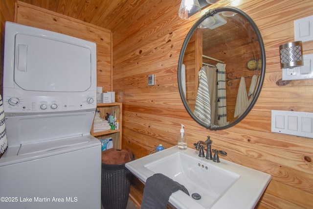 bathroom featuring stacked washer and clothes dryer, sink, wood walls, wooden ceiling, and a shower with shower curtain