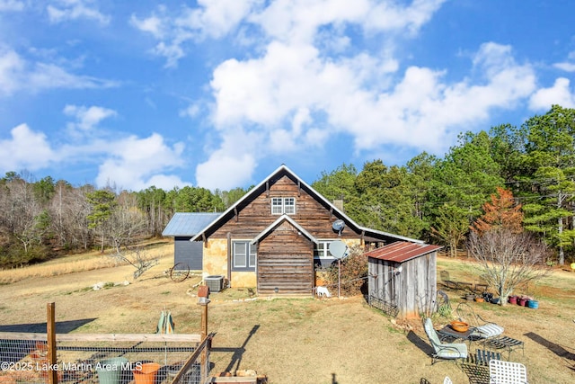 view of front of house featuring cooling unit and a storage unit