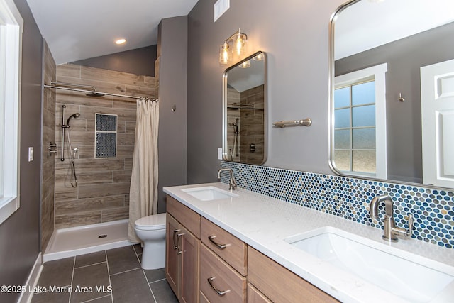 bathroom with a shower with shower curtain, tasteful backsplash, tile patterned floors, vanity, and toilet