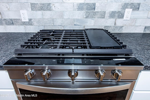 interior details featuring backsplash and stainless steel stove