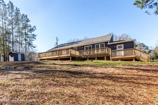 rear view of house with a wooden deck and a storage shed