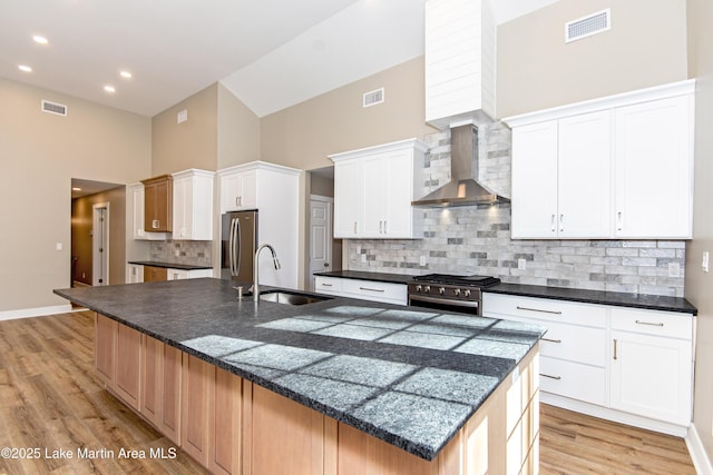 kitchen with appliances with stainless steel finishes, tasteful backsplash, a spacious island, wall chimney range hood, and high vaulted ceiling