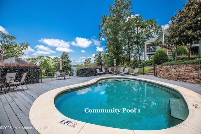 view of pool with fence and a deck