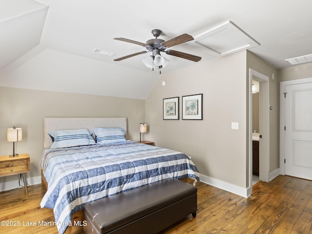 bedroom featuring attic access, lofted ceiling, visible vents, and wood finished floors