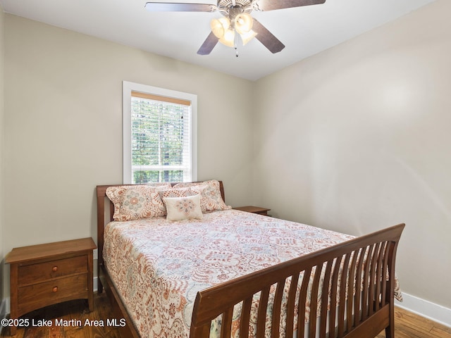 bedroom featuring ceiling fan, baseboards, and wood finished floors