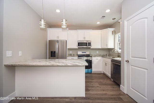 kitchen with white cabinetry, hanging light fixtures, stainless steel appliances, light stone counters, and dark hardwood / wood-style flooring