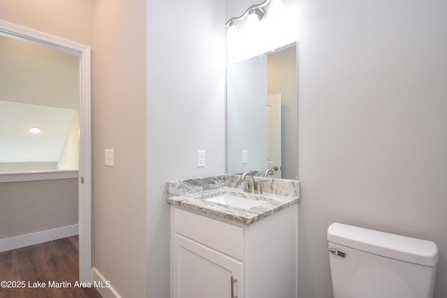 bathroom with vanity, hardwood / wood-style flooring, and toilet