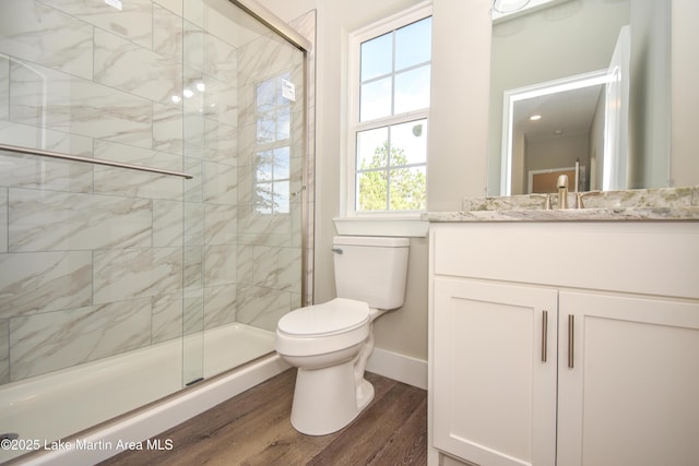 bathroom with hardwood / wood-style floors, vanity, toilet, and an enclosed shower