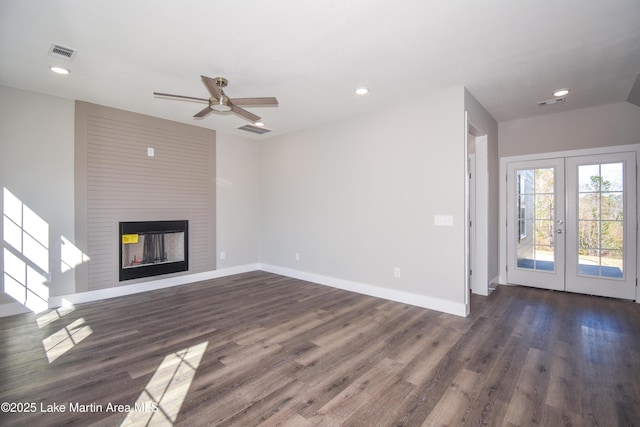 unfurnished living room featuring ceiling fan, a multi sided fireplace, dark wood-type flooring, and french doors